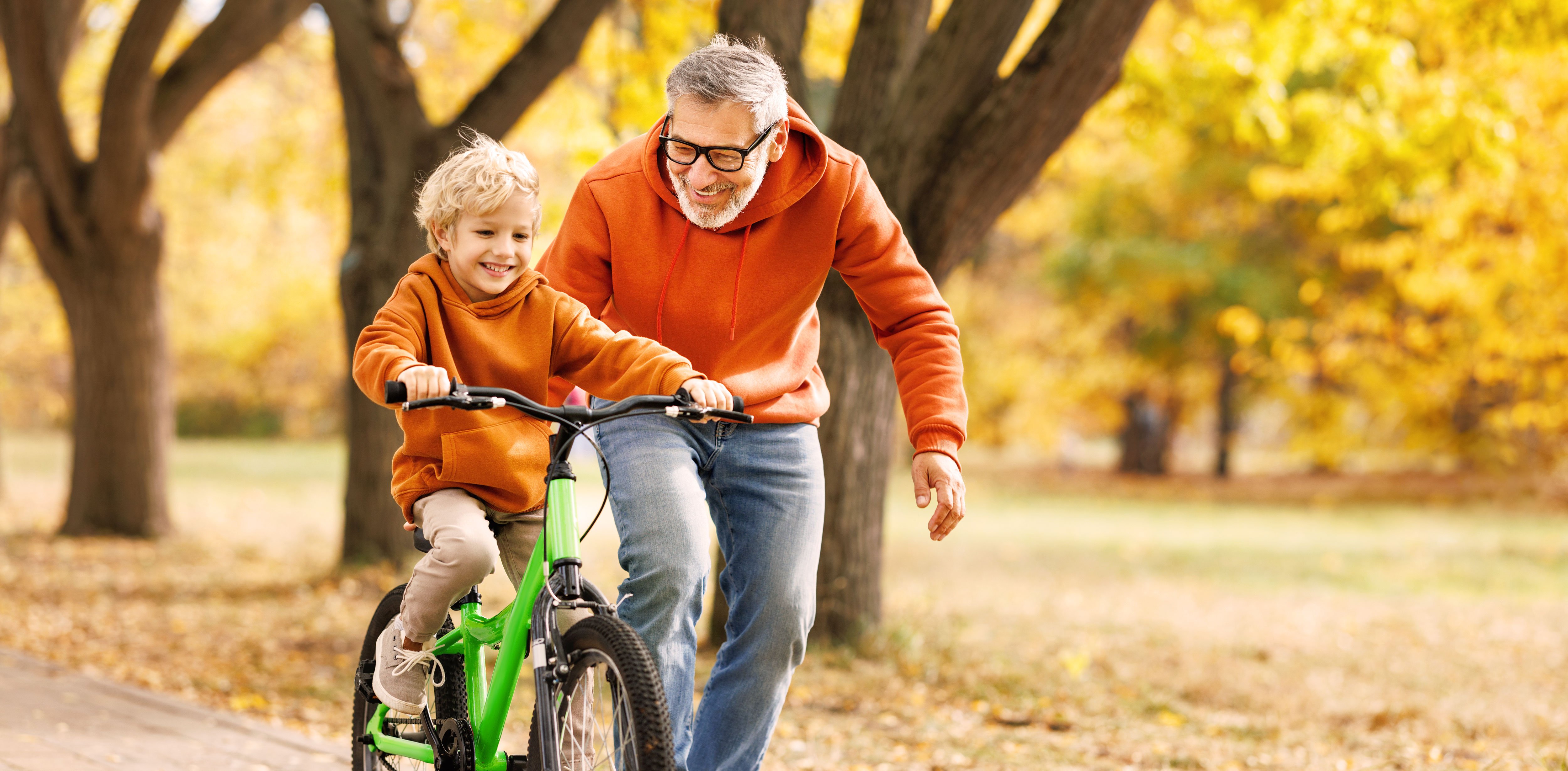 A grandfather sledding with their granddaughter